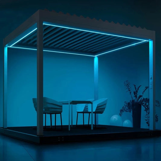 Blue-lit 10x13 motorized aluminum pergola with adjustable louvered roof and integrated LED lighting, dining set underneath